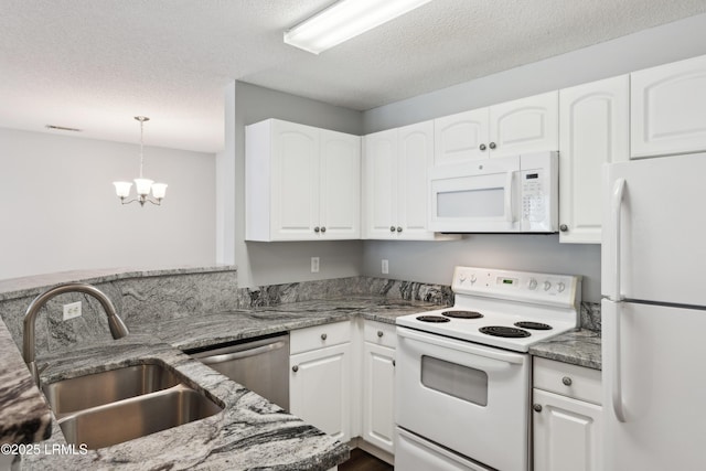 kitchen featuring white cabinets, white appliances, light stone countertops, and a sink