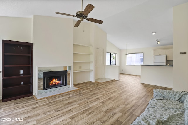 5 Gumtree Rd Unit I-32, Hilton Head Island, SC 29926 - unfurnished living room with ceiling fan, light wood-type flooring, a tile fireplace, high vaulted ceiling, and built in shelves
