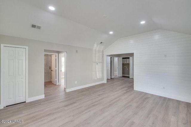 spare room featuring light hardwood / wood-style flooring and vaulted ceiling