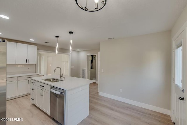 kitchen with sink, hanging light fixtures, a center island with sink, stainless steel appliances, and white cabinets