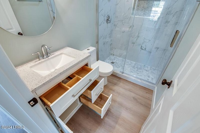 bathroom with an enclosed shower, vanity, hardwood / wood-style flooring, and toilet