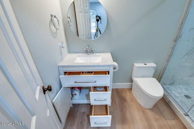 bathroom with hardwood / wood-style flooring, vanity, toilet, and walk in shower