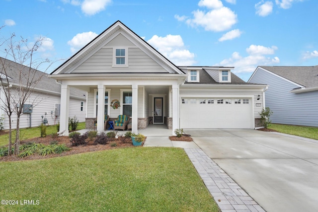 view of front facade featuring a garage, covered porch, and a front lawn