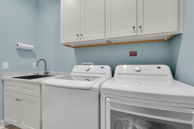 washroom featuring cabinets, washer and clothes dryer, and sink