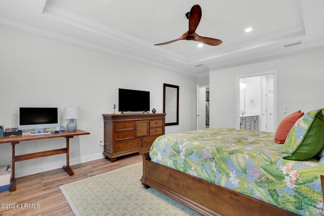 bedroom featuring connected bathroom, a raised ceiling, and ceiling fan