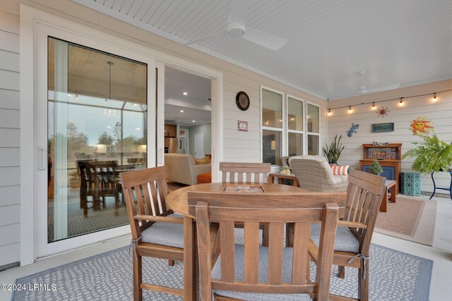 dining space featuring wooden walls and ceiling fan