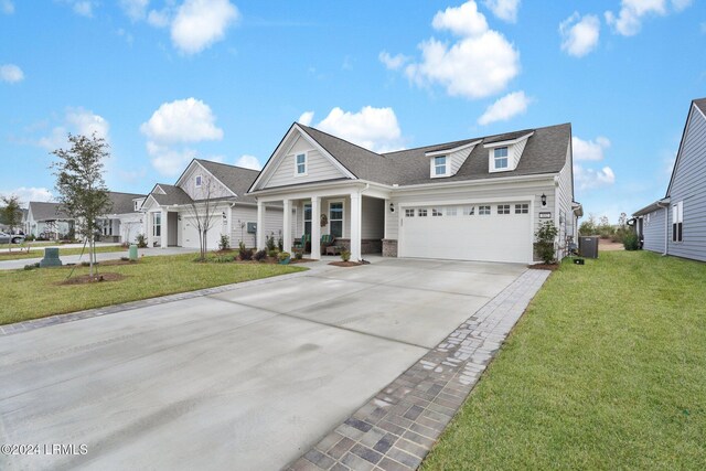 view of front of house with central AC, a garage, and a front lawn