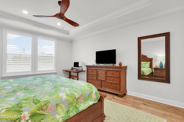 bedroom with crown molding, ceiling fan, a raised ceiling, and light wood-type flooring