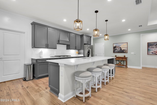 kitchen featuring decorative light fixtures, an island with sink, gray cabinetry, custom exhaust hood, and stainless steel fridge with ice dispenser