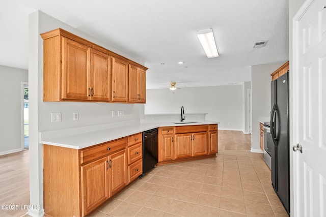 506 Cypress Cv, Bluffton, SC 29910 - kitchen with black appliances, a peninsula, a ceiling fan, light countertops, and brown cabinets