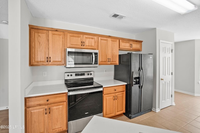506 Cypress Cv, Bluffton, SC 29910 - kitchen featuring appliances with stainless steel finishes, light countertops, light tile patterned floors, and a textured ceiling