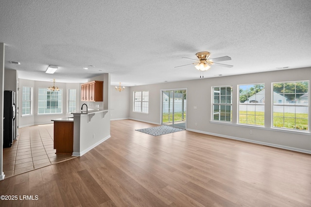 506 Cypress Cv, Bluffton, SC 29910 - kitchen featuring a chandelier, open floor plan, a textured ceiling, a peninsula, and light wood finished floors