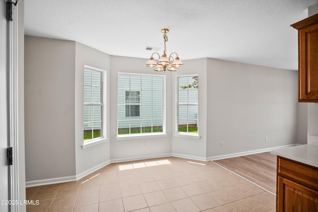 506 Cypress Cv, Bluffton, SC 29910 - unfurnished dining area featuring a chandelier, plenty of natural light, light tile patterned floors, and a textured ceiling