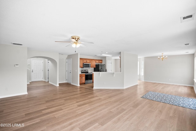506 Cypress Cv, Bluffton, SC 29910 - unfurnished living room featuring arched walkways, ceiling fan, a chandelier, and light wood-type flooring