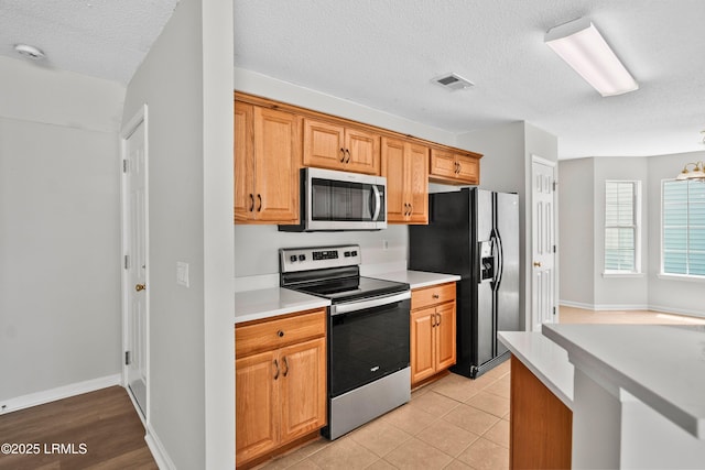 506 Cypress Cv, Bluffton, SC 29910 - kitchen with stainless steel appliances, light countertops, a textured ceiling, and light tile patterned floors