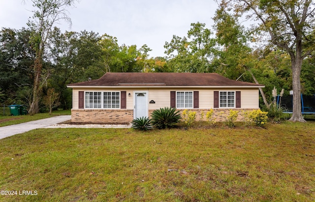 single story home with a trampoline and a front yard