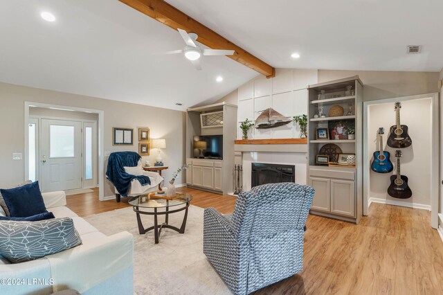 living room with ceiling fan, light wood-type flooring, and vaulted ceiling with beams