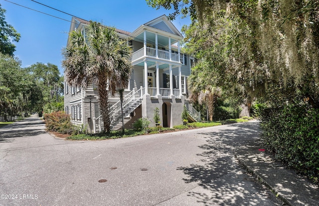 view of property exterior with a porch and a balcony