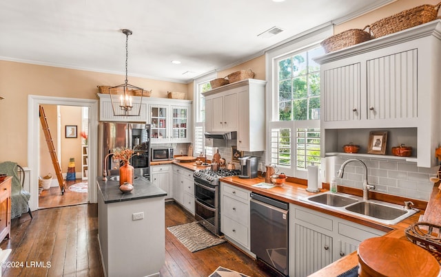 kitchen with pendant lighting, stainless steel appliances, and white cabinets