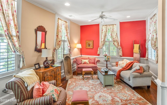 living area featuring ornamental molding, a healthy amount of sunlight, hardwood / wood-style floors, and a fireplace