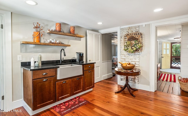 bar with sink and light hardwood / wood-style floors