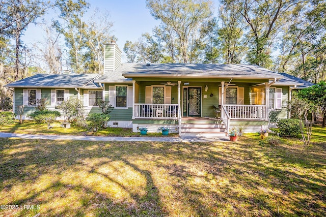 ranch-style home featuring crawl space, a chimney, covered porch, and a front yard