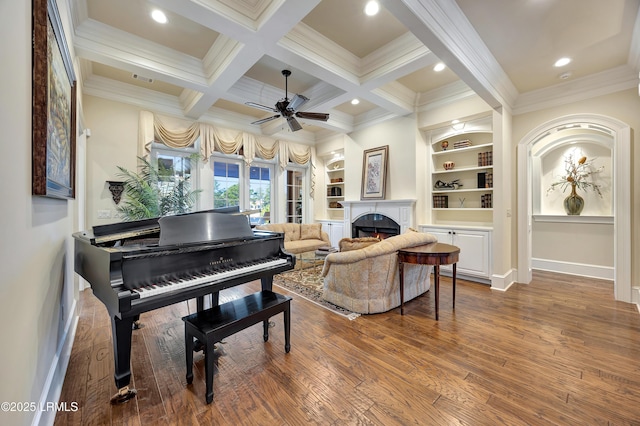 interior space featuring built in features, beamed ceiling, wood-type flooring, coffered ceiling, and crown molding