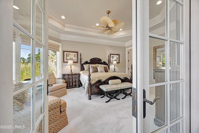 carpeted bedroom with ornamental molding and a raised ceiling