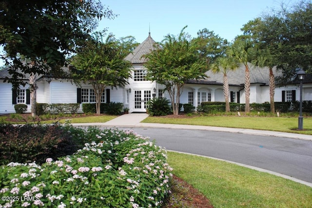 view of front of property featuring french doors and a front lawn