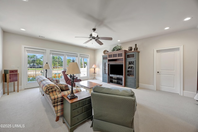 carpeted living room with ceiling fan