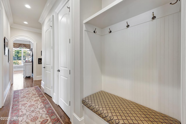 mudroom with crown molding and dark wood-type flooring