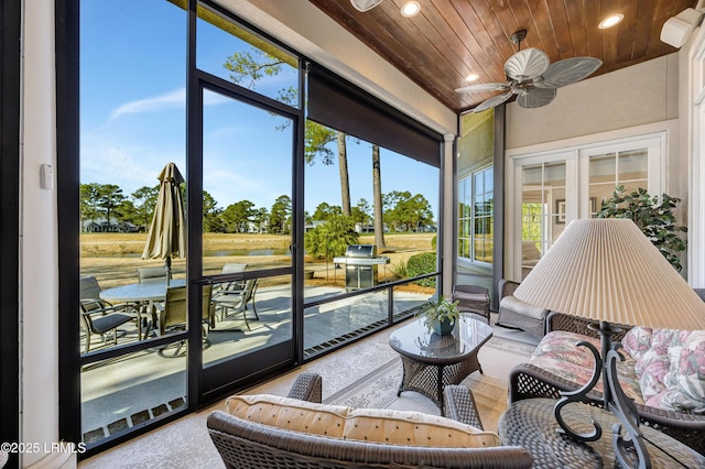 sunroom / solarium with a healthy amount of sunlight, wooden ceiling, ceiling fan, and french doors