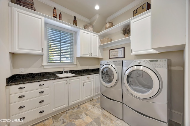 laundry area featuring cabinets, washing machine and clothes dryer, ornamental molding, and sink