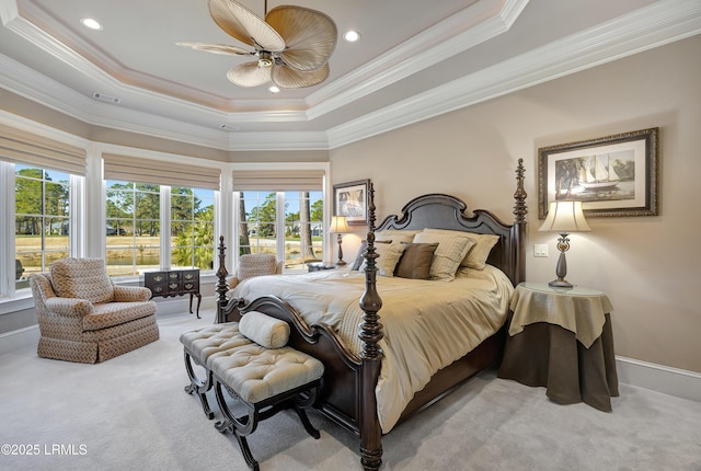 bedroom with ornamental molding, light colored carpet, a raised ceiling, and ceiling fan