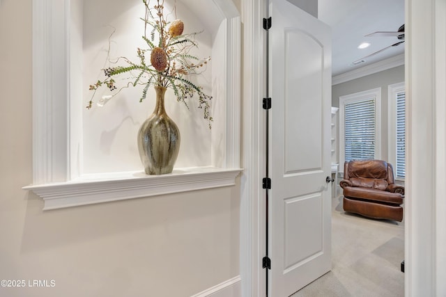 hallway featuring light colored carpet and ornamental molding