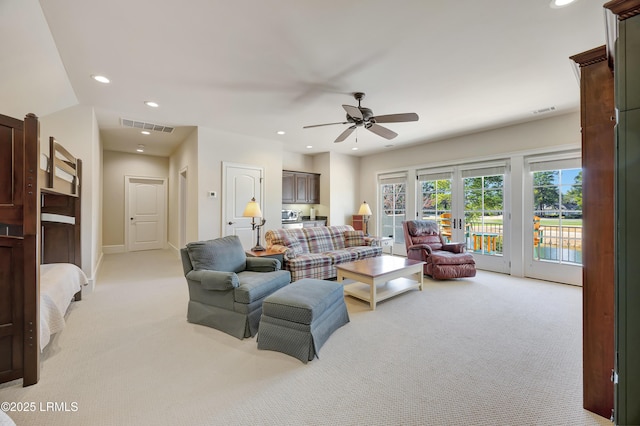 living room with french doors, ceiling fan, and light carpet