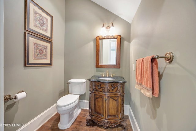 bathroom with vanity, toilet, vaulted ceiling, and hardwood / wood-style floors