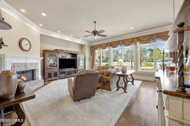 living room with dark wood-type flooring, ceiling fan, and crown molding