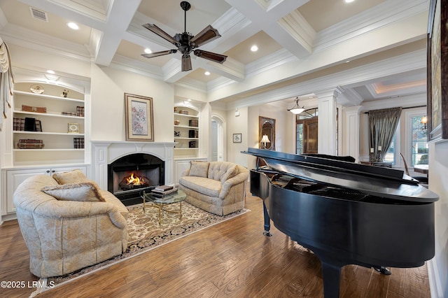 living room featuring coffered ceiling, dark hardwood / wood-style floors, a fireplace, and beam ceiling