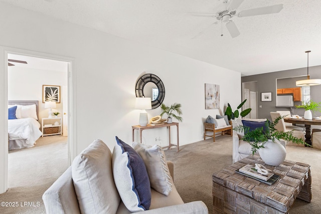 living room featuring light carpet, a textured ceiling, and ceiling fan