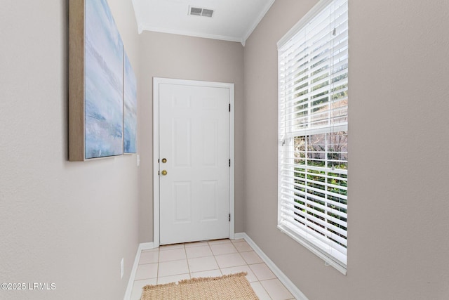 doorway to outside featuring crown molding, light tile patterned floors, and a wealth of natural light