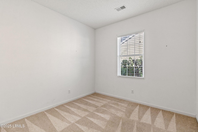 carpeted empty room featuring a textured ceiling