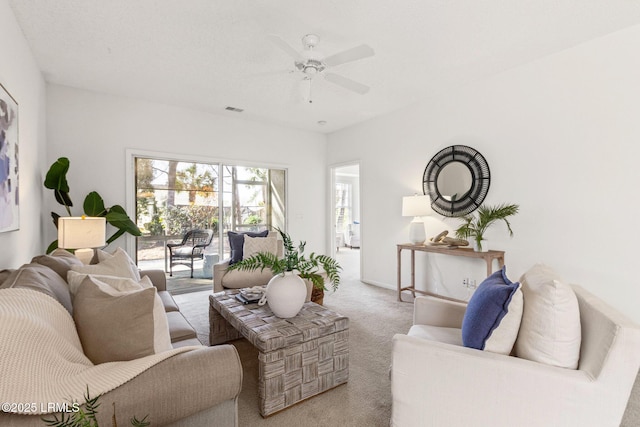 living room with ceiling fan and light colored carpet