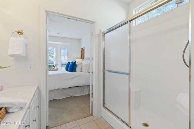 bathroom with vanity, a shower with shower door, and tile patterned floors