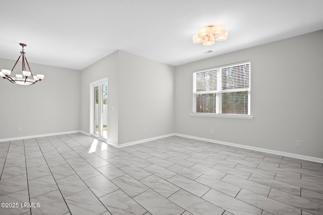 spare room featuring a chandelier