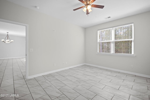 empty room featuring ceiling fan with notable chandelier