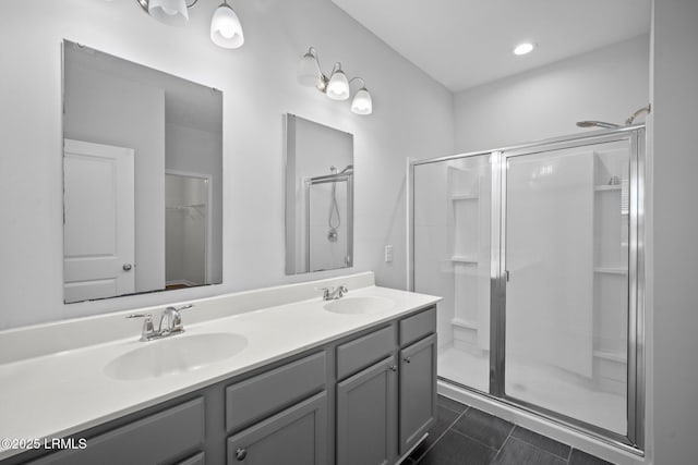 bathroom featuring a shower with door, vanity, and tile patterned floors