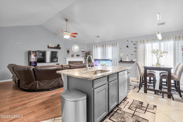 kitchen with a kitchen island with sink, a sink, visible vents, open floor plan, and dishwasher