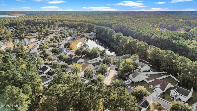 drone / aerial view with a water view, a forest view, and a residential view