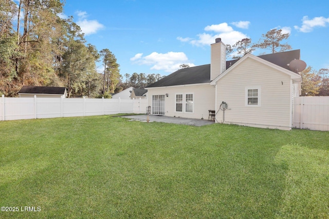 rear view of house with a patio, a yard, and a fenced backyard